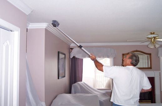 worker from magic mist ceiling cleaning brushing residential ceiling